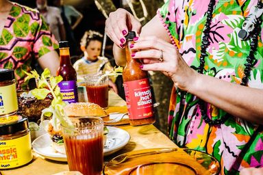 A jar of Yes Yum Hot Sauce is getting opened and ready to pour