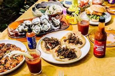 A jar of Yes Yum Hot Sauce sits on the dinner table