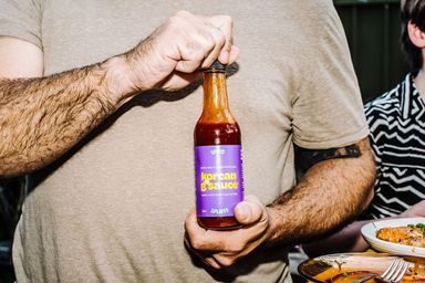 A bottel of Yes Yum Korean G Sauce being held with two hands