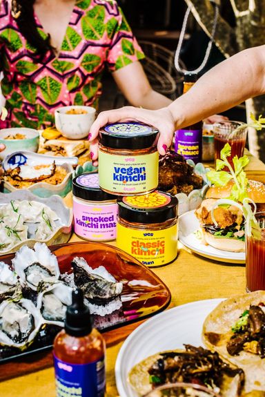 A hand reaches for the jar of vegan kimchi